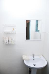 a white bathroom with a sink and a mirror at Talalla Bay Beach House in Talalla