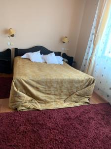 a bedroom with a bed with a blanket on it at Motel Restaurant Lowe in Deva