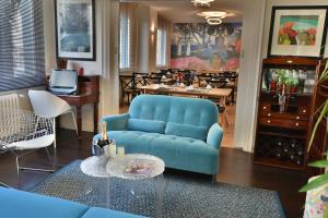 ein Wohnzimmer mit einem blauen Sofa und einem Tisch in der Unterkunft Hôtel Escale Oceania Lorient in Lorient