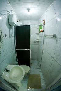 a bathroom with a shower and a toilet and a sink at Pousada Canto da Sereia in Ilha do Mel