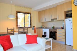a living room with a white couch and a kitchen at Gecko in Tazacorte