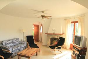 ein Wohnzimmer mit einem Sofa und einem TV in der Unterkunft Club Villamar - Pearl in Calonge