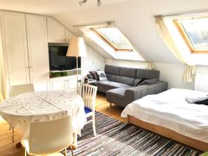 Sala de estar con cama, sofá y mesa en Ferienwohnung Eder, en Pöcking