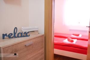 - une chambre avec un lit rouge et une commode en bois dans l'établissement Apartman Ledjanac, à Zlatibor