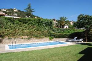 una piscina con 2 sillas junto a un patio en Club Villamar - Tana, en Calonge