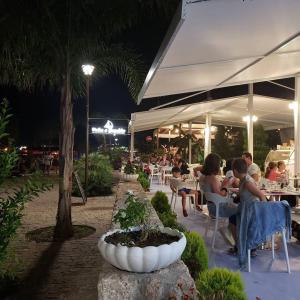 un grupo de personas sentadas en un restaurante por la noche en Vela e Bardhe, en Dhërmi