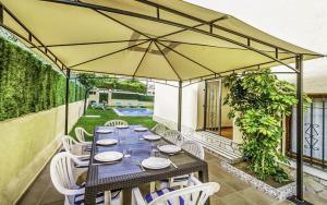 une terrasse avec une table, des chaises et un parasol dans l'établissement Club Villamar - Ruizman, à Calonge