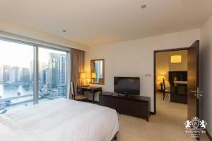 a bedroom with a large white bed and a large window at Westminster Dubai Marina in Dubai