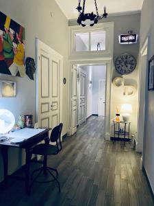 a hallway with a table and chairs and a clock on the wall at Caio Duilio B&B in Messina