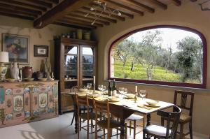 a dining room with a table and a large window at Casa Del Sole in Camaiore