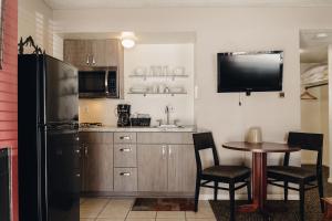 a kitchen with a table and a black refrigerator at Vintage Lakeside Inn in Big Bear Lake