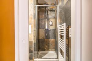 a shower with a glass door in a bathroom at Appartements proche Paris Disney in Torcy +73 photos