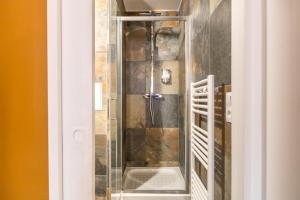 a shower with a glass door in a bathroom at Appartements proche Paris Disney in Torcy