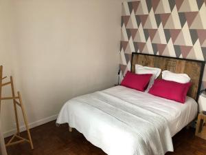 a bedroom with a bed with two red pillows at Gîte des Cailloteux in Couffy +2 photos