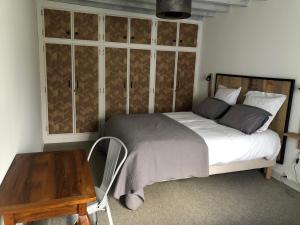 a bedroom with a bed and a wooden table at Gîte des Cailloteux in Couffy