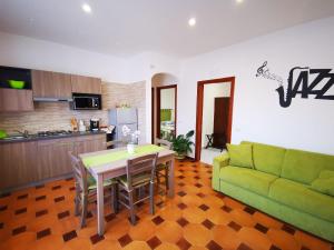 sala de estar con mesa y sofá verde en Jazz & Blues Apartments near " Sentiero degli Dei ", en Agerola