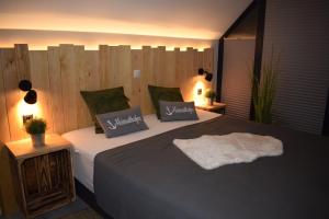 a bedroom with a large bed and a wooden wall at Beach House Seebude in Büsum