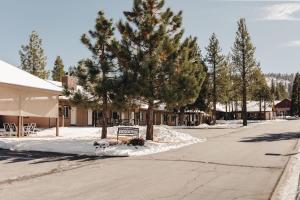 a street with trees and a bench in the snow at Vintage Lakeside Inn in Big Bear Lake