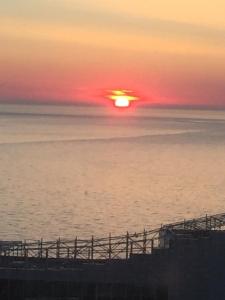 a sunset over a body of water with a pier at batumi porta tower 1811 in Batumi