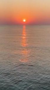 a sunset over the ocean with the sun setting at batumi porta tower 1811 in Batumi