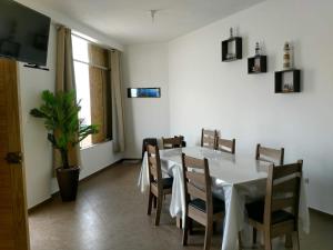 a dining room with a white table and chairs at Camana Beach House in Los Cerrillos