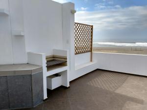 cocina blanca con vistas a la playa en Camana Beach House, en Los Cerrillos