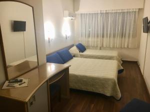 a small room with two beds and a mirror at Hotel Balfers in Montevideo