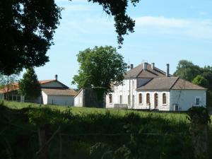 an old white house on a grassy field at La maison triangulaire in Roussines
