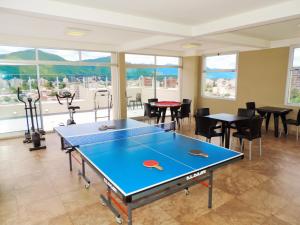 a ping pong table in a room with tables and chairs at Hanan Pacha - Apart Salta in Salta