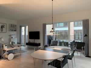 un soggiorno con tavolo, sedie e TV di ApartmentInCopenhagen Apartment 1440 a Copenaghen