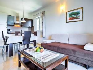 ein Wohnzimmer mit einem Sofa und einem Tisch in der Unterkunft Apartments Villa Tara in Brseč