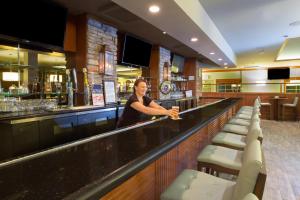 Una donna in piedi in un bar in un ristorante di Holiday Inn Colorado Springs - Airport, an IHG Hotel a Colorado Springs