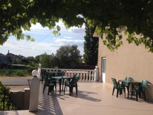 a patio with tables and chairs and a fence at v LAD i MIR Guesthouse in Zatoka