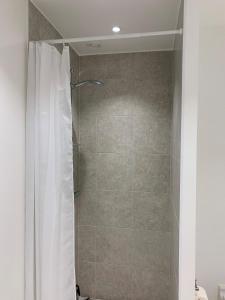 a shower with a white shower curtain in a bathroom at ApartmentInCopenhagen Apartment 1440 in Copenhagen