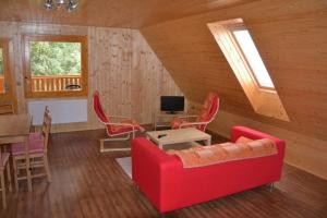 uma sala de estar com um sofá vermelho e uma mesa em Penzion Diana em Kunžak