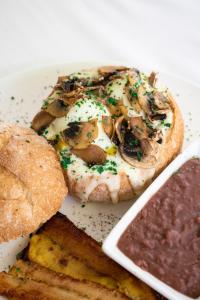 a plate of food with mushrooms and bread and dips at Il Buongustaio in San Salvador