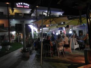 un gruppo di persone sedute al ristorante di notte di Sun City a Kato Daratso