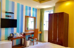 a room with a bedroom with a desk and a mirror at CONTENTO RETREAT in Hulhumale