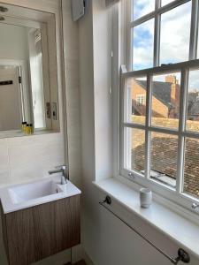 Un baño con lavabo y ventana. en CC - Central Location Top Floor 2 Bed Deluxe Modern Apartment, en Stratford-upon-Avon 17 fotos más