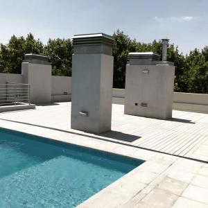 een zwembad naast een wit hek en bomen bij Medrano Kind in Buenos Aires