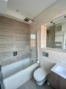 a bathroom with a toilet and a tub and a sink at CC - Central Location Top Floor 2 Bed Deluxe Modern Apartment in Stratford-upon-Avon