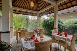 an outdoor dining area with tables and chairs at Nadira Bali Villa in Munduk