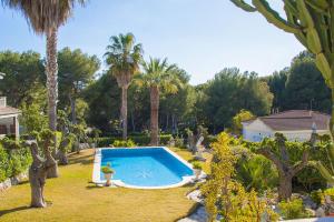 una piscina en un patio con palmeras en Club Villamar - Gaudi Stil, en Cunit