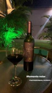 una botella de vino junto a una copa de vino en Itacimirim - Quinta das Lagoas Residence, en Itacimirim