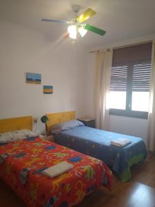 1 dormitorio con 2 camas y ventilador de techo en Mediterraneo, en Masnou