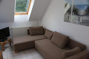 een woonkamer met een bank en een tv bij Nordseepier in Horumersiel