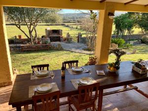 een houten tafel op een patio met uitzicht op een veld bij Cugnana Country Escape in Olbia