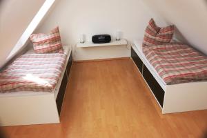 a attic room with two beds and a wooden floor at Nordseepier in Horumersiel