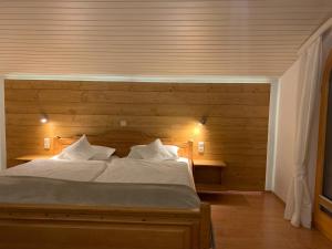 1 dormitorio con 1 cama grande y pared de madera en Ferienwohnung am Römerweg Wald, en Inzell