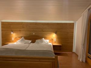 a bedroom with a large bed with a wooden wall at Ferienwohnung am Römerweg Wald in Inzell